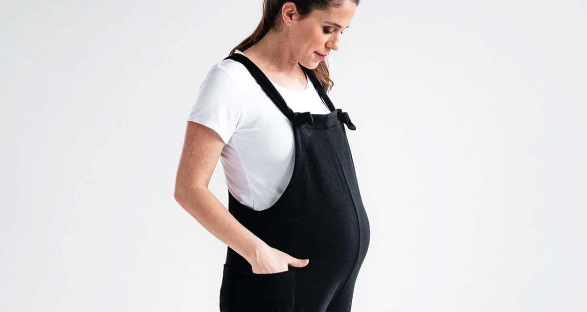 Pregnant mom wearing comfortable maternity clothes, smiling, and showcasing everyday maternity wear