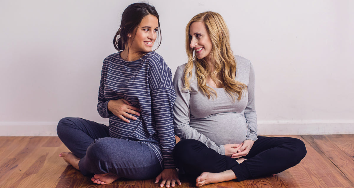 Woman in soft maternity pants with belly panel, natural light, neutral home setting