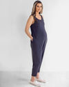 A pregnant woman wearing a navy maternity jumpsuit with a scoop neck and ankle length.