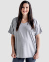 A pregnant woman wearing a gray Boardwalk Loose Maternity T Shirt with a relaxed fit and scoop V-neck.